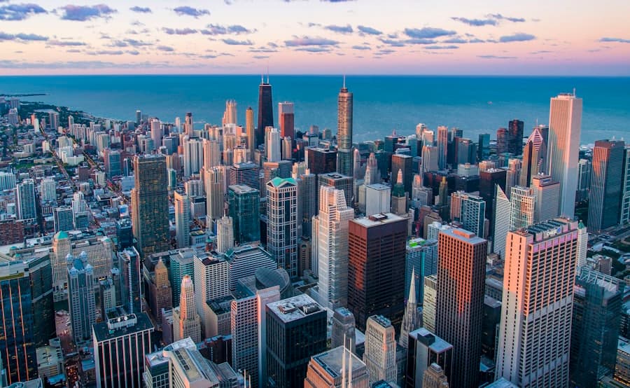 City skyline at dusk with lit streets running toward the horizon